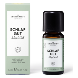 Flasche mit ätherischen Ölen für Schlafunterstützung, umgeben von einer hellgrünen Verpackung mit dem Titel 'Schlaf Gut'.